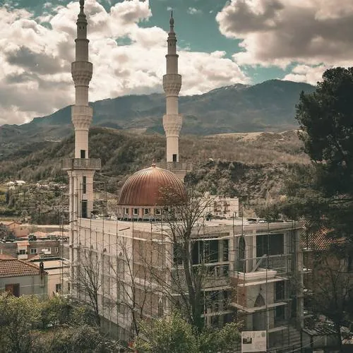 Xhami me kupolë bakri dhe minare me elemente dekorative, në mes të maleve